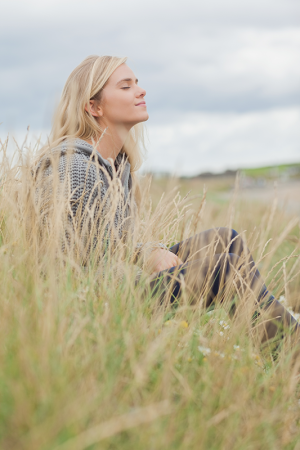 side-view-cute-thoughtful-woman-sitting-beach